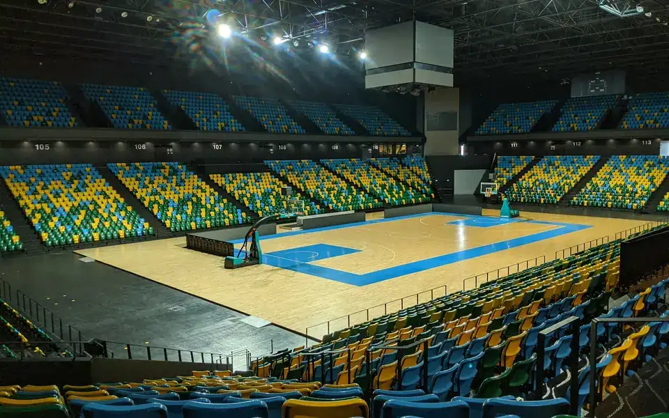 Arena de básquetbol vacía con la duela iluminada